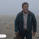 Royal Abbott (Josh Brolin) stands in a misty field, holding his cowboy hat in his hand.